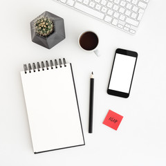 Mobile mockup, notebook, coffee and cactus on white office desk. Flat lay.