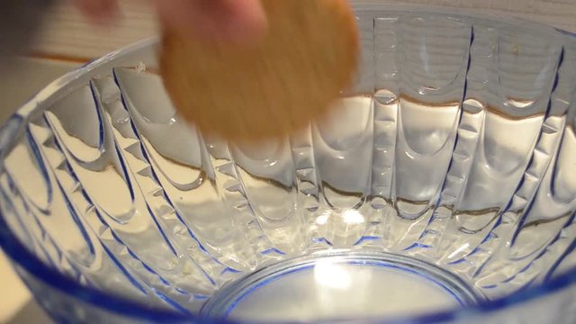 Woman hand taking last cookie buiscut from blue glass bowl shugar addiction concept