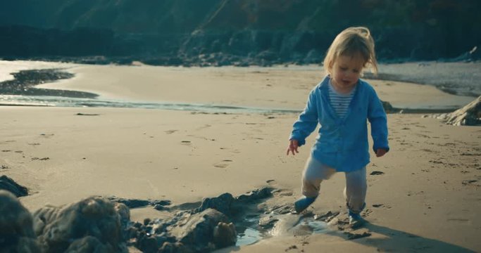 Little toddler getting his feet wet on the beach