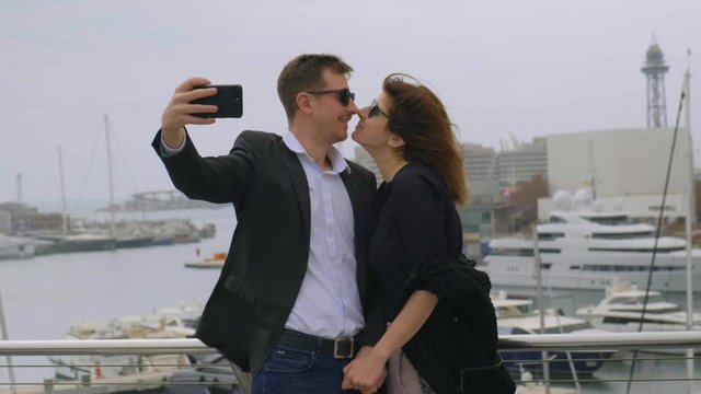oung Beautiful couple in Love making selfies on the rooftop at the City Harbour 
