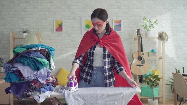 Housewife superhero girl stroking clothes