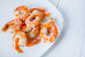 fried shrimps on a white plate on a white wooden table