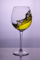 Splash of white wine in a glass on the table