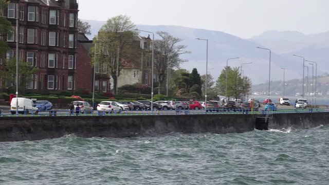 Choppy waters of the River Clyde on a windy day crashing against the esplanade wall at Greenock.