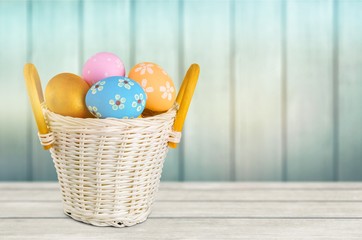 Easter basket filled with colorful eggs on a white background