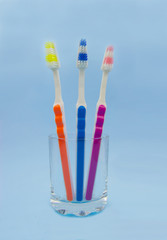 Toothbrushes in a glass, blue background