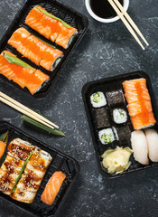 Various kinds of sushi served on black stone background.