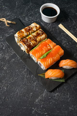 Various kinds of sushi served on stone background.