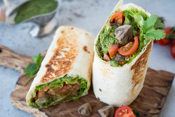 Burrito wraps with vegetables and sauce pesto.Roll with vegetables, mushrooms and pesto sauce. Vegetarian kebab. Of diet food.