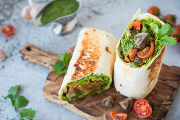 Burrito wraps with vegetables and sauce pesto.Roll with vegetables, mushrooms and pesto sauce. Vegetarian kebab. Of diet food.