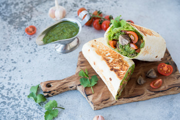 Burrito wraps with vegetables and sauce pesto.Roll with vegetables, mushrooms and pesto sauce. Vegetarian kebab. Of diet food.