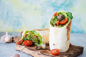 Burrito wraps with vegetables and sauce pesto.Roll with vegetables, mushrooms and pesto sauce. Vegetarian kebab. Of diet food.