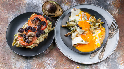 Tasty breakfast. Sandwich with tomatoes and mushrooms, basil, avocado, fried eggs with asparagus. Top view
