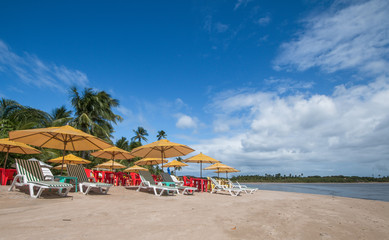 Fototapeta na wymiar Beach chairs and umbrellas on tropical beach