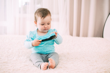 little girl with a blue comb in a blue jacket on the bed