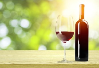 Red wine glass and buttle on wooden desk background