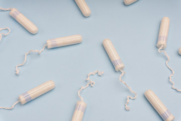 Menstruation concept with tampons and pads on bright blue background. Woman menstruation cycle concept.