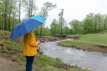 Woman in the rain watching a stream in Arkansas