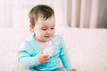 a little girl yourself holding the mask of the nebulizer, making inhalation
