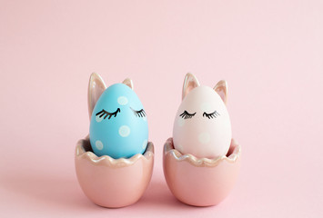 Easter decorated eggs with close eyes on pink background. Minimal Easter holiday concept. Happy Easter card with copy space for text, flat lay 