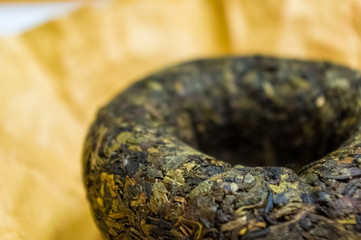 Chinese pressed puer tea on wrapping paper, close-up, macro