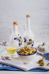 Grilled olives with garlic, olive oil and spices on rustic wooden background