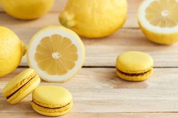 Yellow french macarons with lemons on the wooden board