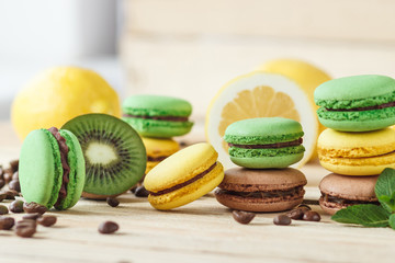 Green and yellow french macarons with kiwi, lemon and mint decorations
