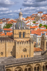 Aerial view of the medieval building of Coimbra Cathedral, Coimbra city and sky as background, Portugal