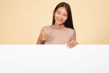 Fototapeta premium Young Asian woman show thumbs up with blank sign.