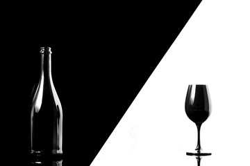 Black champagne bottle with black champagne glass isolated on black and white background