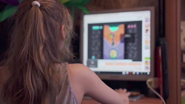 Girl plays a computer game on a computer