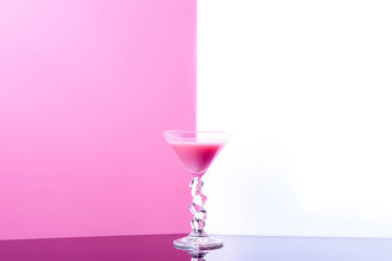 martini glass on white and pink background