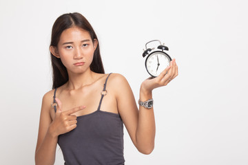 Angry young Asian woman point to a clock.