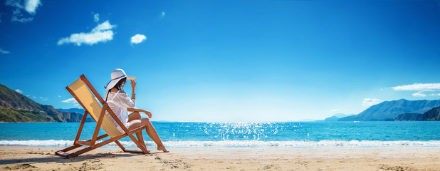 Woman Enjoying Sunbathing at Beach - obrazy, fototapety, plakaty