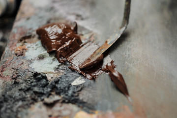 Woman artist draws a palette knife. Oil paints of different colors on the palette.