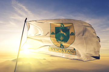 Yucatan state of Mexico flag waving on the top sunrise mist fog