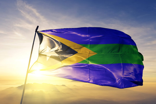 Manatuto municipality of East Timor flag waving on the top sunrise mist fog