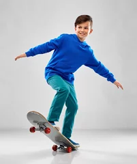 Foto op Canvas childhood, leisure and people concept - smiling boy in blue hoodie with skateboard over grey background © Syda Productions