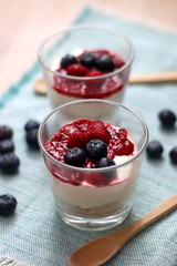 Simple no-bake raspberry cheesecake in a glass. Decorated with blueberries. Selective focus.