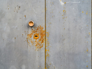 Old metal doors are stained with rust. Handle and door lock.
