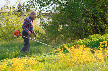 man mows the lawn grass with a lawn mower