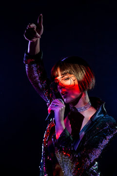 Stylish woman singing on stage
