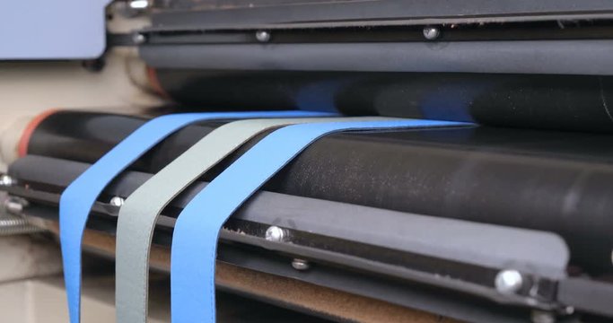 In slow motion, the machine straightens the zippers of clothes in the garment factory, then heats it up. Concept of: Work, Factory, Clothing, Industry, Garment Factory.