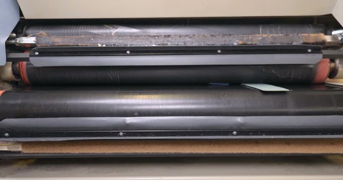 In slow motion, the machine straightens the zippers of clothes in the garment factory, then heats it up. Concept of: Work, Factory, Clothing, Industry, Garment Factory.