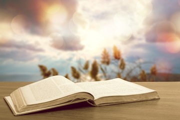Open book on old wooden table.