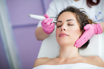 Beautiful woman in professional beauty salon during photo rejuvenation procedure