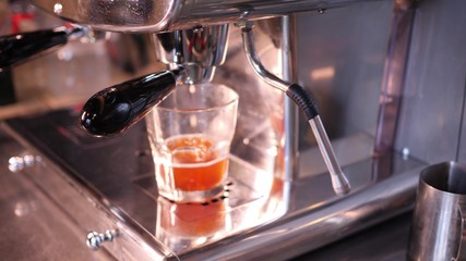 making fresh juice in a large steel juicer in a city cafe in slow motion 4K video.