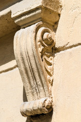 Stone carved corbel under the window of an old building-diagonal view, colorful picture. © Тамара Селиванова