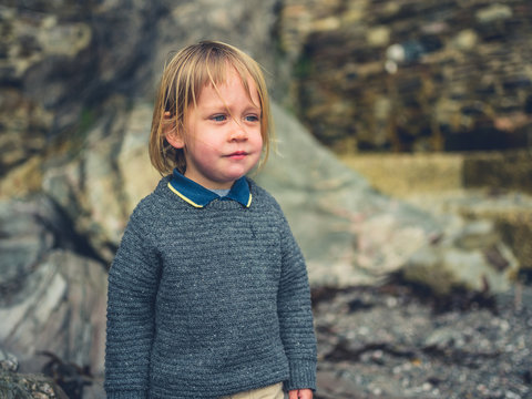 Little toddler standing on a rocky beach